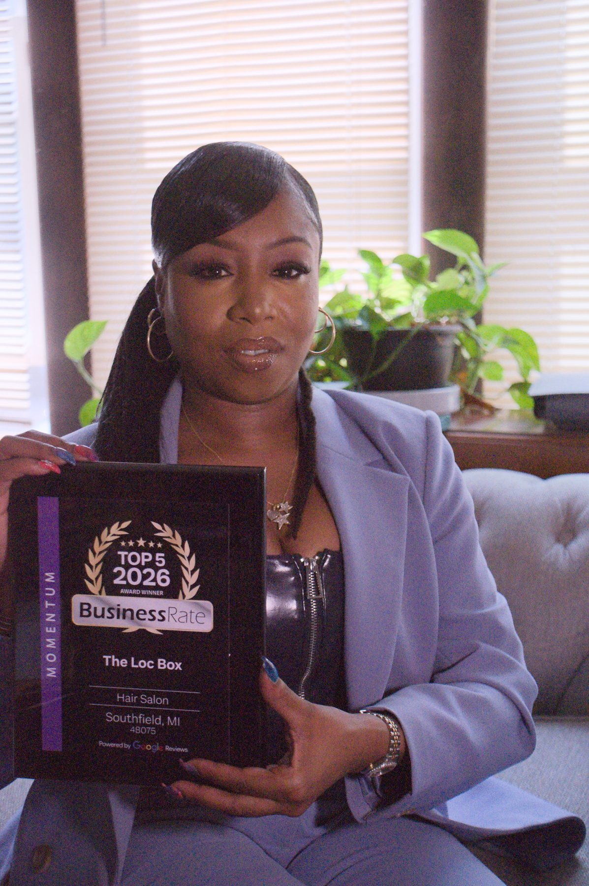 The Loc Box owner holding the Top 5 2026 BusinessRate award for hair salon in Southfield, Michigan